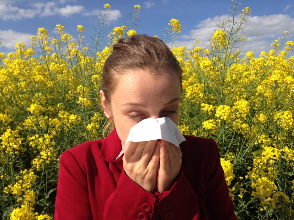 A young girl closing her nose with handkerchief